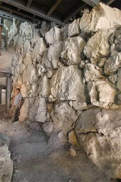 The newly discovered wall on Mt Ophel. Note the human figure at the far left who gives scale to the stones that make up the wall.